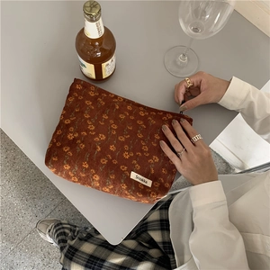 Vue détaillée de la trousse en velours côtelé caramel à fleurs avec étiquette