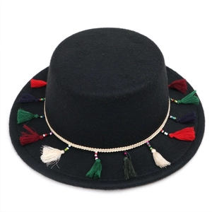 Gros plan d'un chapeau canotier noir avec des glands colorés et des perles bohèmes