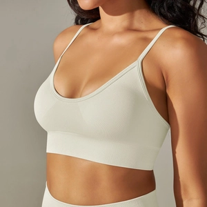 Close-up of off-white seamless sports bra with thin straps and ribbed texture detail