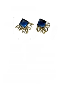 Detailed view of square coil earrings featuring blue crystals and 14K gold plating