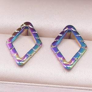 Detailed macro view of rainbow plated geometric rhombus earrings in stainless steel