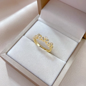 Macro detail of leaf-shaped adjustable gold ring with sparkling zircon in a jewelry box