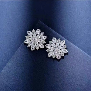 Sparkling S925 sterling silver snowflake earrings with cubic zirconia on blue background