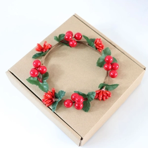 Detailed top view of a Christmas candle ring with red berries and green artificial leaves