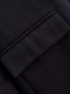 Detail shot of black dress blazer pocket with refined lace hem and premium fabric texture