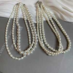 Detailed close-up of triple-layered freshwater pearl necklace with silver clasps