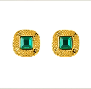 Macro detail of vintage square gold stud earrings featuring a green zircon center stone