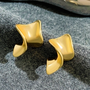 Macro shot of abstract geometric gold-finish alloy earrings with artistic textured folds