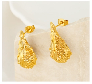 Macro shot of gold-plated titanium earrings with organic drop shape and wavy texture