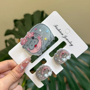 Three-piece set of cute grey hippo hair clips and claw clip on a white display card
