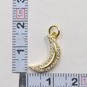 Close-up of gold moon pendant with cubic zirconia stones showing 2cm size measurement