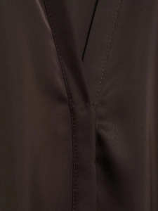 Detailed close-up of dark brown satin shirt stitching and fine woven fabric texture