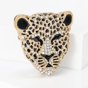 Dettaglio della spilla a leopardo dorata con strass bianchi e finiture in smalto