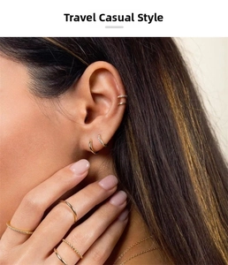 Detailed view of minimalist gold earrings and stacked rings on a female model