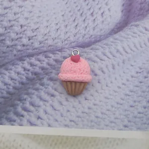 Macro detail of a resin ice cream charm with pink cream and heart for DIY jewelry making