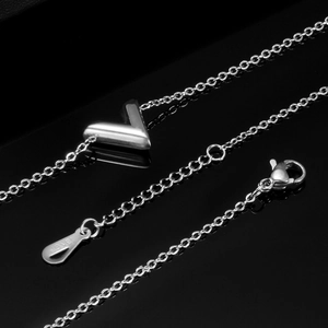 Detailed close-up of silver V-shaped pendant and 18KGP hallmark on the jewelry clasp