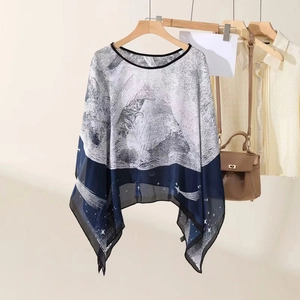 Blau-weißer Chiffon-Poncho mit abstraktem Sternmuster auf einem Holzbügel