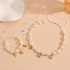 Detail of white shell necklace and bracelet set with golden starfish and dolphin charms
