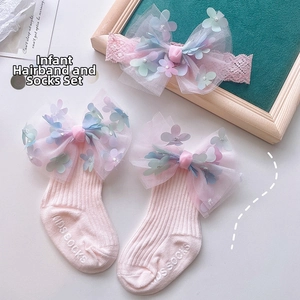 Detail of pink baby headband and socks with mesh flowers and large bows for newborns