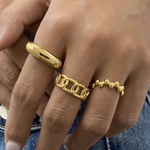 Detailed view of women gold-tone stainless steel ring set with plain and rope textures