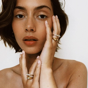 Anelli minimalisti in acciaio inossidabile oro e argento sulle mani di una modella