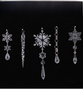 Detail of five acrylic snowflake and icicle ornaments with transparent crystal cutting