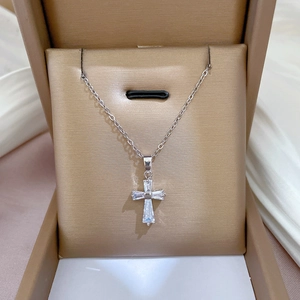 Titanium steel cross pendant necklace with cubic zirconia displayed in a brown jewelry box