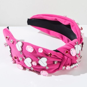 Detailed view of rose red knotted headband with rhinestone heart and arrow charm decor