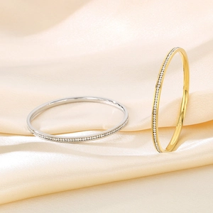 Detailed close-up of gold and silver titanium steel bangles with sparkling crystals