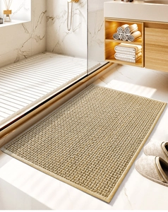 Detail of beige chenille bath mat with soft woven texture placed by a shower