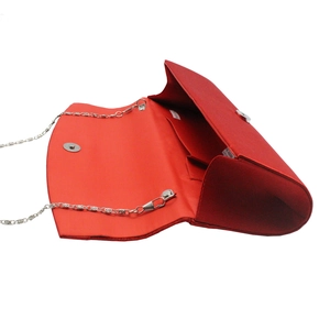 Interior detail of red satin evening clutch with silver chain strap and magnetic closure