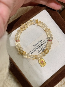Gros plan du bracelet en perles avec pendentif cœur et dieu dans son écrin