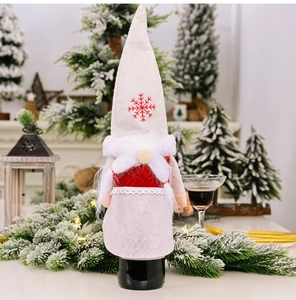 Detail of Christmas gnome wine bottle cover with red snowflake hat and white faux fur