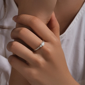 Macro shot of a s925 silver ring featuring a central pearl and sparkling side diamonds