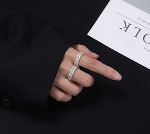 Detail of silver and gold plated eternity rings with baguette-cut cubic zirconia on fingers