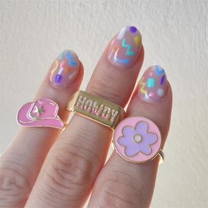 Three-piece set of gold plated enamel rings with cowboy hat and flower daisy designs