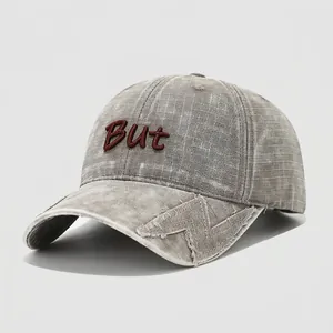 Close-up of vintage dark grey plaid kids baseball cap with But embroidery and frayed details