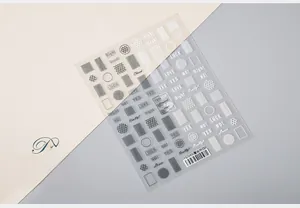 Close-up of 5D nail art stickers with lace patterns and English typography on a beige background