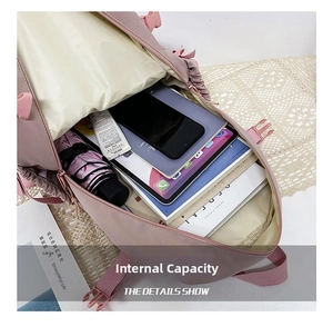 Detail view of the spacious pink backpack interior holding a phone, umbrella, and books