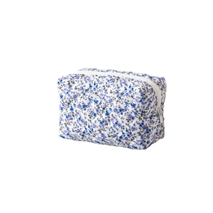 Floral quilted makeup bag with blue flower pattern and secure zipper closure