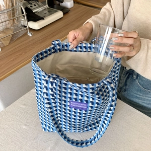 Detail view of the blue plaid tote bag showing its spacious interior and functional zip pocket