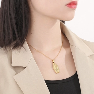 Dettaglio di una collana con ciondolo Vergine Maria in acciaio placcato oro 18K su modella