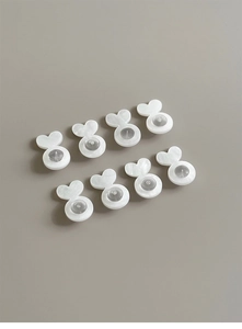 Detailed view of eight heart-shaped silicone earring backs in white for support