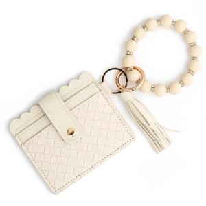 Macro shot of cream woven card holder with bead wristlet and elegant tassel charm detail