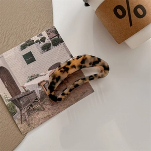 Chic tortoiseshell acetate hair claw clip shown in an elegant lifestyle setting