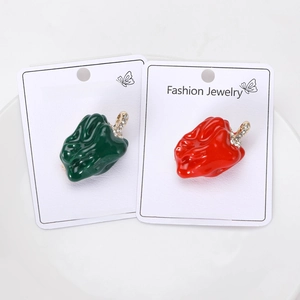 Detail of red and green chili brooches with enamel finish and sparkling rhinestones