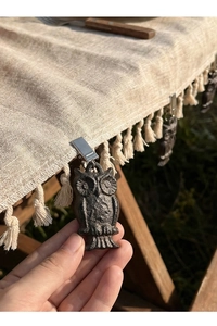 Détail d'un poids de nappe en fonte vintage en forme de hibou avec pince en métal