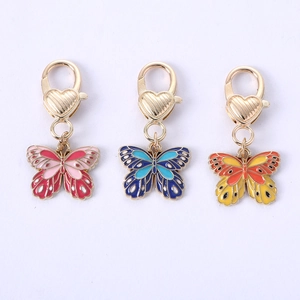 Three colorful butterfly keychains in pink blue and yellow with gold heart clasps
