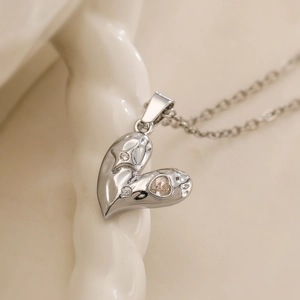 Silver heart pendant necklace with three clear gemstones on minimalist link chain