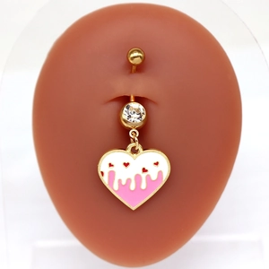 Macro de piercing nombril cœur doré avec émail rose coulant sur modèle en silicone